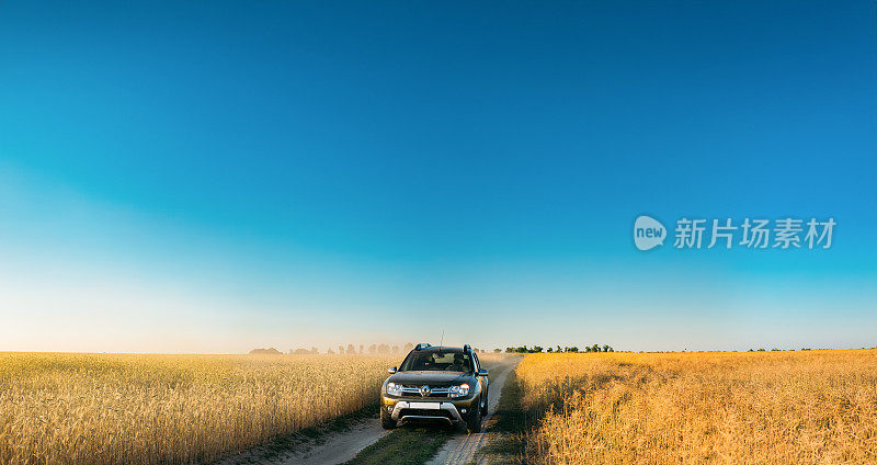 夏日麦田乡村景观中的雷诺Duster或达契亚Duster SUV。达斯特是由法国雷诺汽车公司及其罗马尼亚子公司达契亚公司联合生产的